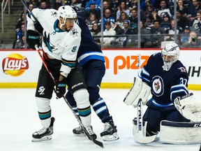 Winnipeg Jets goalie Connor Hellebuyck (37) makes a save with San Jose Sharks forward Evander Kane (9) looking for a rebound during the first period  at Bell MTS Place in Winnipeg on Feb. 14, 2020.