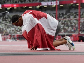 Canada's Andre De Grasse celebrates with the flag of Canada after winning the men's 200m final during the Tokyo 2020 Olympic Games at the Olympic Stadium in Tokyo on August 4, 2021. (Photo by Javier SORIANO / AFP) (Photo by JAVIER SORIANO/AFP via Getty Images)