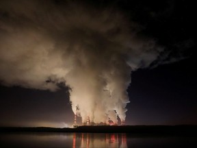 Smoke and steam billows from Belchatow Power Station, Europe's largest coal-fired power plant operated by PGE Group, at night near Belchatow, Poland, Dec. 5, 2018.