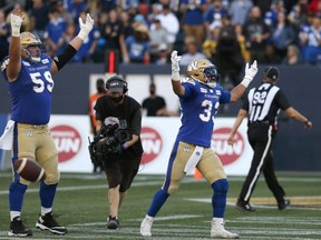 Winnipeg Blue Bombers RB Andrew Harris (right) and OL Michael Couture celebrate a rushing touchdown from Harris against the Calgary Stampeders at IG Field. KEVIN KING/Winnipeg Sun