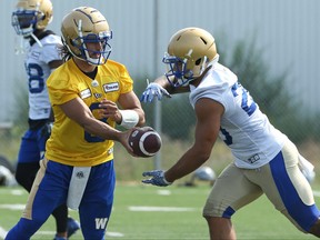 Zach Collaros (left) hands off to Brady Oliveira during Winnipeg Blue Bombers training camp on the University of Manitoba campus in Winnipeg on Sunday, July 18, 2021.