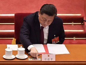 China's President Xi Jinping votes on changes to Hong Kong's election system during the closing session of the National People's Congress at the Great Hall of the People in Beijing on March 11, 2021.