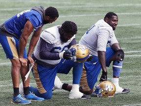 Offensive lineman Jermarcus Hardrick (right) takes a breather while Stanley Bryant (centre) and defensive lineman Jackson Jeffcoat talk during Winnipeg Blue Bombers practice on Tues., Aug. 10, 2021. KEVIN KING/Winnipeg Sun/Postmedia Network