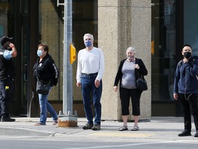 Masked pedestrians keep their distance at a downtown  Winnipeg intersection on Thurs., Aug. 26, 2021. KEVIN KING/Winnipeg Sun/Postmedia Network