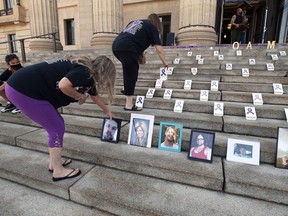 Photographs of loved ones lost are placed on the steps the Manitoba Legislative Building in Winnipeg during an event marking International Overdose Awareness Day on Tuesday, Aug. 31, 2021.