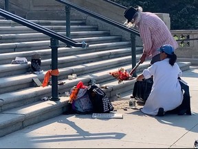 Two anti-vaccine protesters were seen destroying a memorial to residential school victims on Thursday. (Lynn Giesbrecht/Leader-Post)