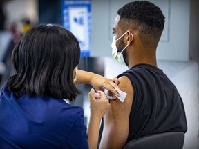 Risks with the vaccine are far less than those associated with getting COVID, writes Dr. Christopher Labos. Above: Karl Contout gets his shot at a vaccination site on Parc Ave.