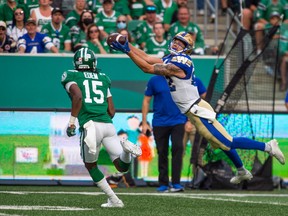 Winnipeg Blue Bombers wide receiver Drew Wolitarsky (82) makes a catch under pressure from Saskatchewan Roughriders safety Mike Edem (15) during second half CFL action in Regina.  The Winnipeg Blue Bombers defeated the Saskatchewan Roughriders 23-8 on Sunday, September 5, 2021.  (CFL PHOTO - Matt Smith)