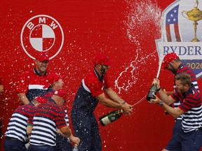 Team USA's Dustin Johnson sprays champagne on his teammates as they celebrate after winning the Ryder Cup against Team Europe.