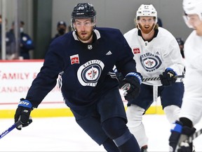 Pierre-Luc Dubois (left) chases the puck during the first day of Winnipeg Jets training camp on Thursday.