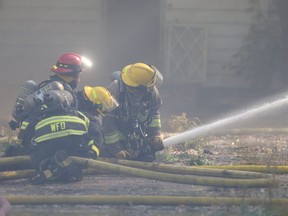 Winnipeg fire fighters battle a blaze in the vicinity of The Louise Bridge, in Winnipeg on Tuesday, Sept. 28, 2021.