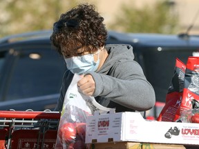 A woman wearing a mask loads groceries in south Winnipeg on Monday, Sept. 27, 2021.