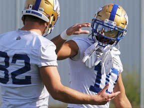 Slotback Nic Demski (right) greets wide receiver Drew Wolitarsky during Winnipeg Blue Bombers practice on the University of Manitoba campus on Monday.
