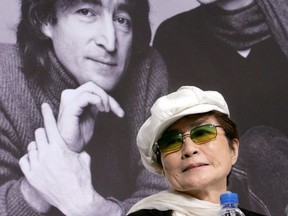 Yoko Ono, the wife of the late singer John Lennon, listens to reporters' questions in front of a portrait of Lennon and herself at a news conference in Tokyo October 4, 2005.