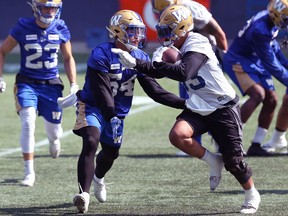 Linebacker Les Mauro (left) meets running back Andrew Harris in the hole during Winnipeg Blue Bombers practice at IG Field on Wednesday, Sept. 1, 2021