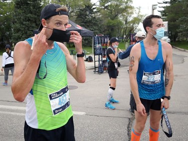 Manitoba Marathon winner Brian Walker (left) masks up in the finish area on Chancellor Matheson in Winnipeg with second-place finisher Tom Sherwin on Sunday, Sept. 5, 2021.