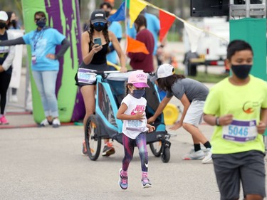 A member of the Negrych family gets out ahead of her group at the start line of the Manitoba Marathon 5K Fun Run on Chancellor Matheson Road in Winnipeg on Sunday, Sept. 5, 2021.