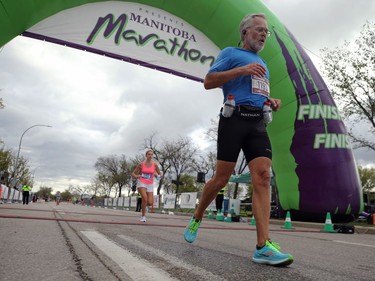 Half marathon participant Dale Friesen crosses the finish line at the Manitoba Marathon on Chancellor Matheson Road in Winnipeg on Sunday, Sept. 5, 2021.