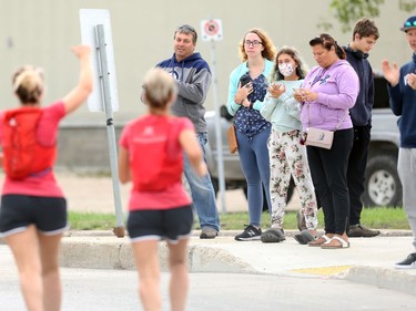 A runner gives the thumbs up to people cheering along Point Road at Pembina Highway during the Manitoba Marathon in Winnipeg on Sunday, Sept. 5, 2021.