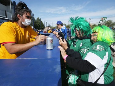 Saskatchewan Roughriders fans attempt to use technology in the tailgate area ahead of the Banjo Bowl battle against the Winnipeg Blue Bombers and Saskatchewan Roughriders in Winnipeg on Saturday, Sept. 11, 2021.