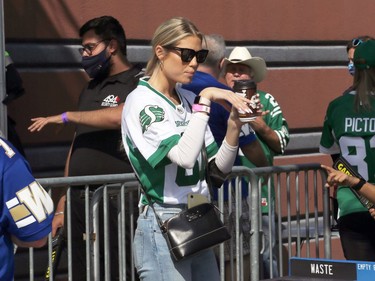 A Saskatchewan Roughriders fan finishes her coffee before heading into IG Field for the Banjo Bowl battle against the Winnipeg Blue Bombers in Winnipeg on Saturday, Sept. 11, 2021.