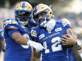 Winnipeg Blue Bombers QB Sean McGuire (right) celebrates his second rushing touchdown of the game against the Saskatchewan Roughriders during the Banjo Bowl in Winnipeg with RB Andrew Harris on Saturday, Sept. 11, 2021.