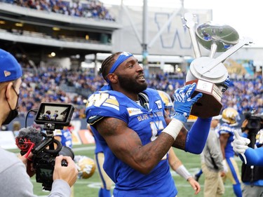 Winnipeg Blue Bombers DE Willie Jefferson hoists the Banjo Bowl trophy after beating the Saskatchewan Roughriders in Winnipeg on Saturday, Sept. 11, 2021.