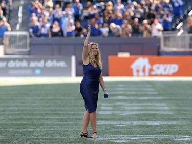 Jennifer Hanson waves to the crowd after singing the national anthem prior to the Banjo Bowl in Winnipeg between the Blue Bombers and Saskatchewan Roughriders  on Saturday, Sept. 11, 2021.