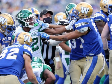 An official tries to step in as a brawl breaks out between the Winnipeg Blue Bombers and Saskatchewan Roughriders at the Banjo Bowl in Winnipeg on Saturday, Sept. 11, 2021.