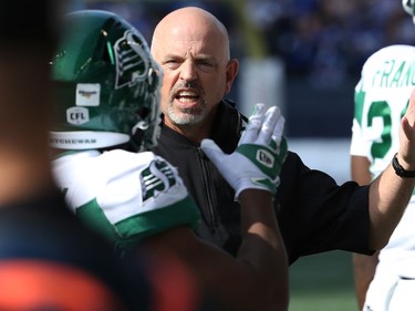 Saskatchewan Roughriders head coach Craig Dickenson speaks with a player on the sideline during the Banjo Bowl against the Blue Bombers in Winnipeg on Saturday, Sept. 11, 2021.