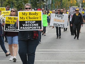 COVID-19 vaccination passport protesters march down Broadway from the Manitoba Legislative Building grounds to City Hall in Winnipeg on Monday, Sept. 13, 2021.