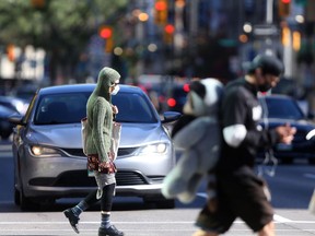 People cross the street in downtown Winnipeg on Tuesday afternoon. The province is reporting 70 new COVID-19 cases on Wednesday. Chris Procaylo/Winnipeg Sun