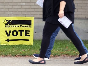People have their voter cards ready as they head toward a polling station at Centre Culturel Franco-Manitobain in Winnipeg on Mon., Sept. 20, 2021.