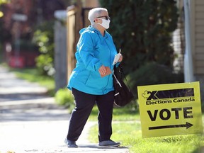 A woman wearing a mask heads for an advance polling station on Mulvey Avenue in Winnipeg on Mon., Sept. 13, 2021. KEVIN KING/Winnipeg Sun/Postmedia Network