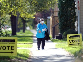 A woman wearing a mask heads for an advance polling station on Mulvey Avenue at Harrow Street in Winnipeg on Mon., Sept. 13, 2021. KEVIN KING/Winnipeg Sun/Postmedia Network