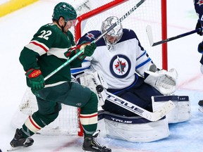 Connor Hellebuyck  of the Winnipeg Jets makes a save as Kevin Fiala of the Minnesota Wild looks for the rebound in the third period at Xcel Energy Center on Tuesday.