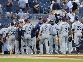 The Tampa Bay Rays celebrate after defeating the New York Yankees 12-2 at Yankee Stadium at Yankee Stadium in New York on Oct. 2, 2021. The Rays’ victory was the team’s 100th of the season.