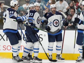 Jansen Harkins (12) of the Winnipeg Jets celebrates with teammates after scoring a goal against the San Jose Sharks in the third period at SAP Center on October 16, 2021 in San Jose, Calif.