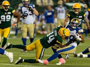 Edmonton Elks’ Keishawn Bierria (44) tackles Winnipeg Blue Bombers’ Brady Oliveira (20) during second half CFL football action at Commonwealth Stadium in Edmonton, on Friday, Oct. 15, 2021.