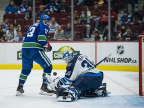 Winnipeg Jets goalie Mikhail Berdin makes a save against Vancouver Canucks forward Justin Dowling at Rogers Arena Sunday night.  USA TODAY SPORTS