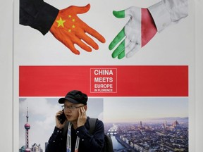 A man takes a call next to a poster stating "China meets Europe in Florence" at China International Fair for Trade in Services in Beijing, May 28, 2019.