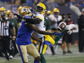 Blue Bombers’ Darvin Adams (left) can’t get his hands on the ball as Edmonton Elks’ Jonathan Rose defends during  first-half action last night.