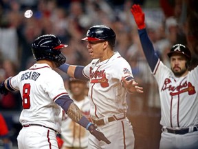 Braves left fielder Eddie Rosario (left) celebrates with third baseman Ehire Adrianza (centre) after hitting a three-run home run during the fourth inning against the Dodgers in Game 6 of the 2021 NLCS at Truist Park in Cumberland, Ga., Oct 23, 2021.