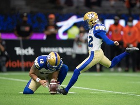 CP-Web.  Winnipeg Blue Bombers' Ali Mourtada, right, kicks a field goal as Sean McGuire holds during the second half of a CFL football game against the B.C. Lions in Vancouver, on Friday, October 1, 2021. THE CANADIAN PRESS/Darryl Dyck ORG XMIT: VCRD245