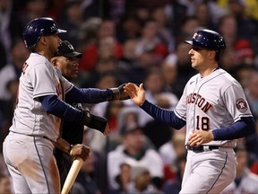 Jason Castro is congratulated by Yuli Gurriel of the Houston Astros after Castro scored in the ninth inning against the Boston Red Sox in Game 4 of the American League Championship Series at Fenway Park on Oct. 19, 2021 in Boston.