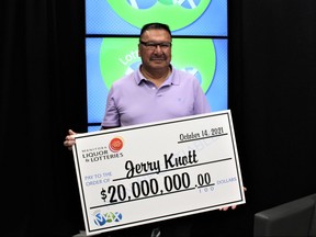Jerry Knott of Wasagamack, Man., poses with his cheque after winning $20 million in the Aug. 24 Lotto Max draw.