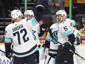 Seattle Kraken defenceman Mark Giordano (5) and forward Joonas Donskoi (72) celebrate with teammates after the first win in franchise history at Bridgestone Arena.