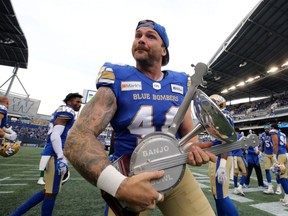 Winnipeg Blue Bombers LS Mike Benson celebrates with the Banjo Bowl trophy after beating the Saskatchewan Roughriders in Winnipeg on Sat., Sept. 11, 2021. KEVIN KING/Winnipeg Sun/Postmedia Network