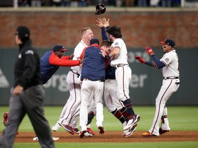 Atlanta Braves third baseman Austin Riley (27) celebrates his walk off RBI driving in Atlanta Braves second baseman Ozzie Albies (1) for the game winning run against the Los Angeles Dodgers during the ninth inning of Game 1 of the 2021 NLCS at Truist Park in Atlanta on Oct. 16, 2021.