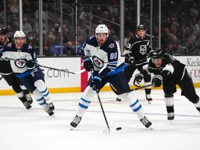 Oct 28, 2021; Los Angeles, California, USA; Winnipeg Jets center Pierre-Luc Dubois (80) and LA Kings right wing Viktor Arvidsson (33) battle for the puck in the first period at Staples Center. Mandatory Credit: Kirby Lee-USA TODAY Sports